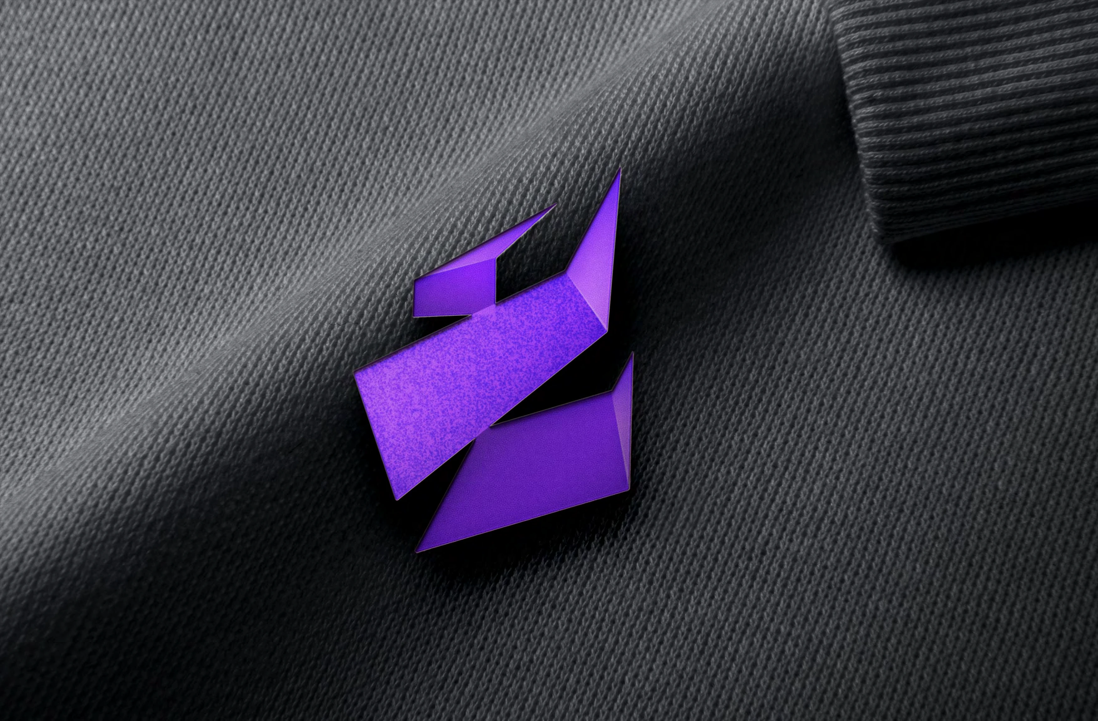 Purple Ambire symbol on black textured fabric